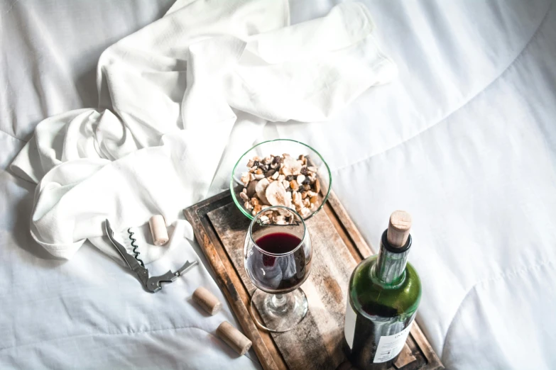 a glass bottle of wine next to bottles and corks