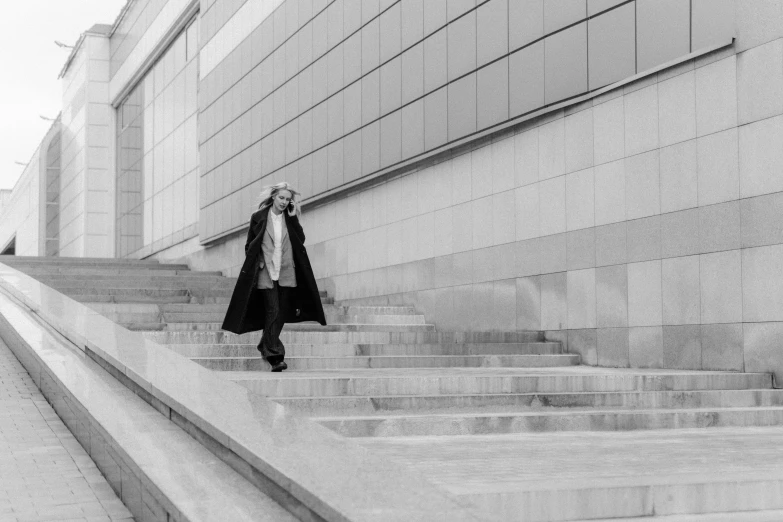 woman walking down steps from the building with two hands