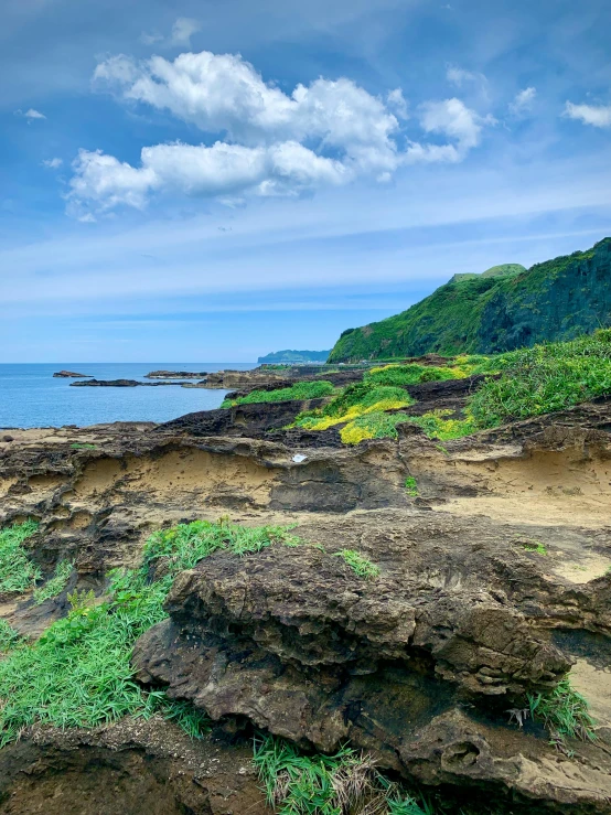 two benches sitting on top of rocks near the ocean