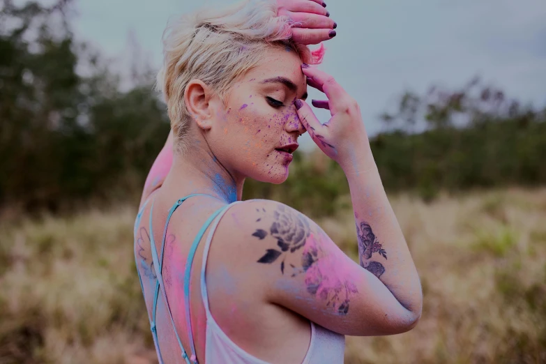 a woman is covered with colored powder in the field