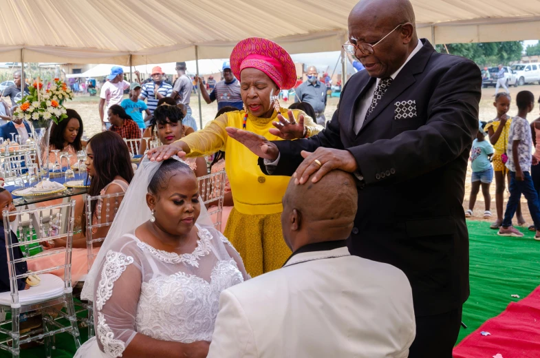 the people are gathered around the groom and bride