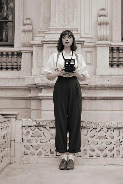 a woman with a camera standing on a sidewalk