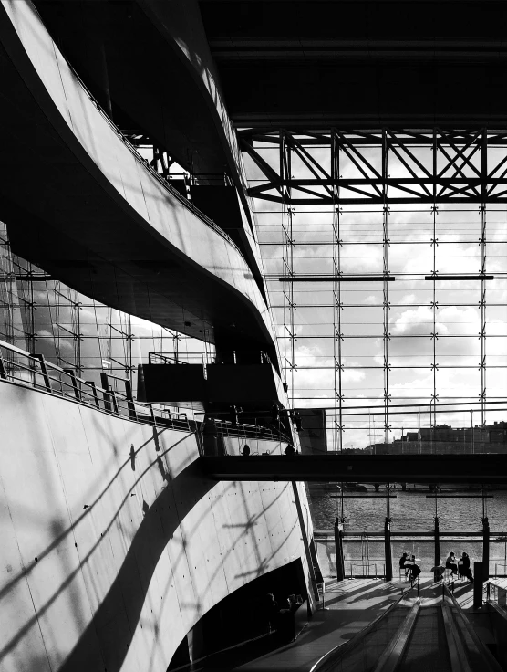 people walk and sit near the large window