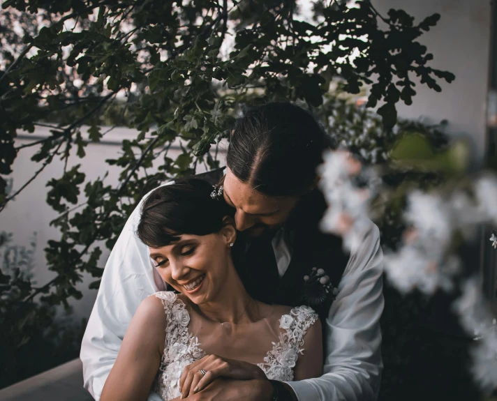 a bride and groom holding each other while emcing