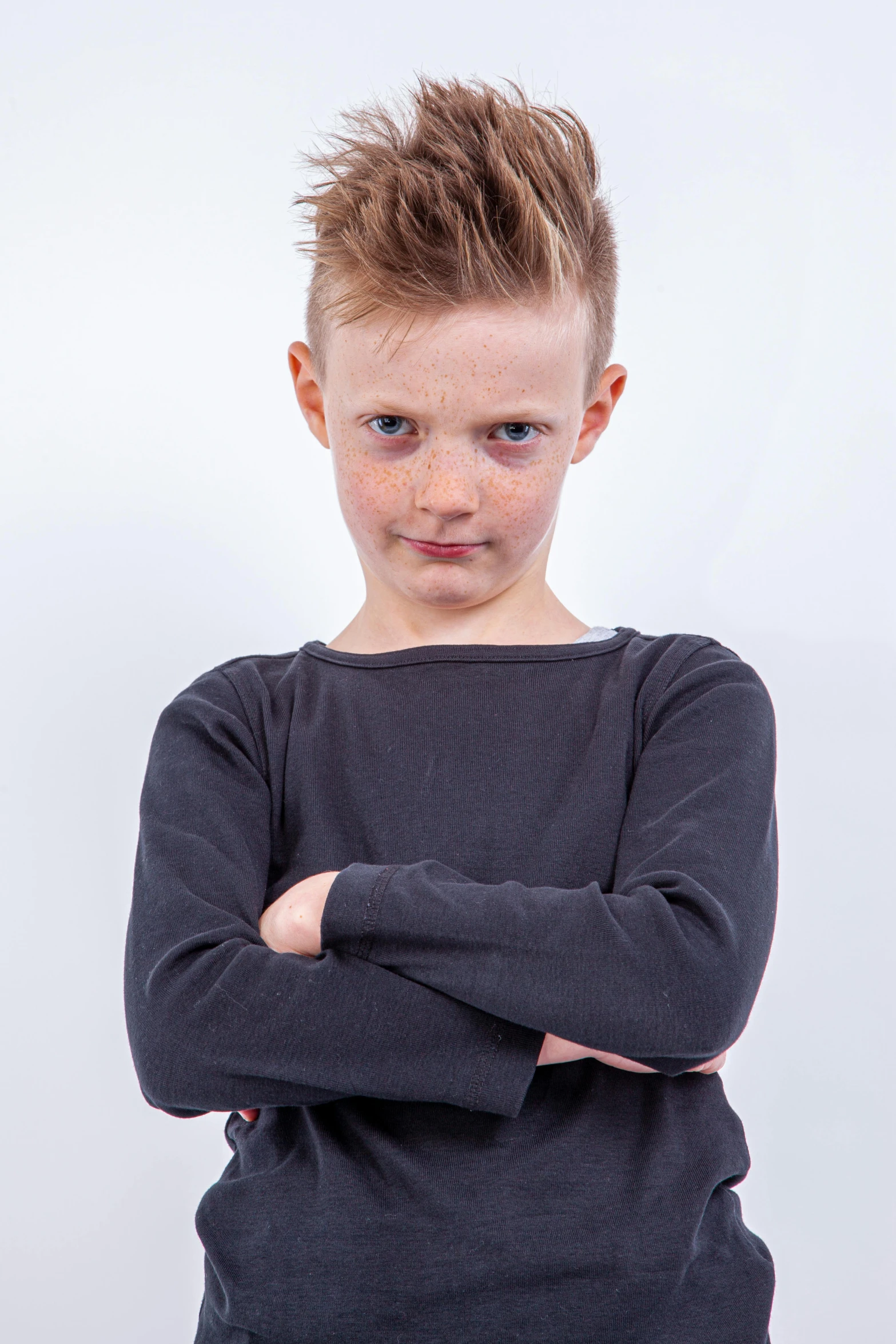 a boy with the arms crossed wearing a black top