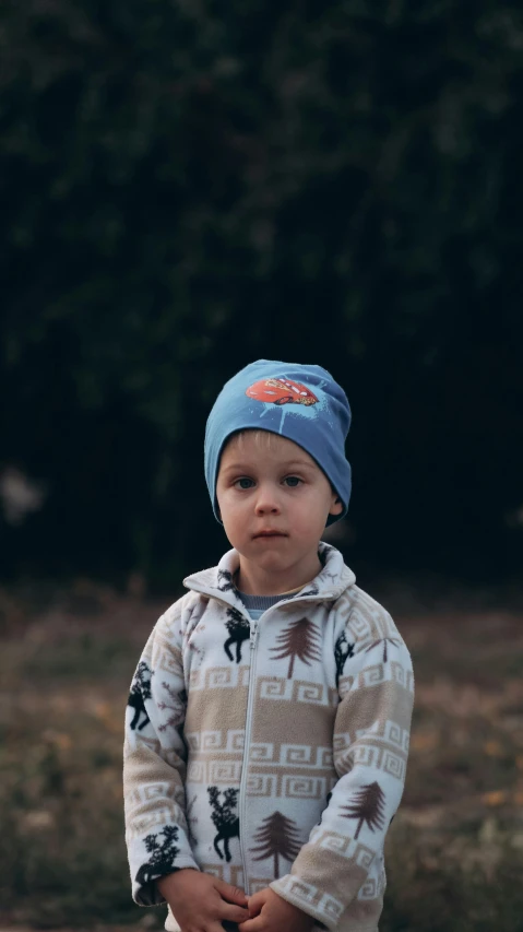 a little boy standing in the middle of a field