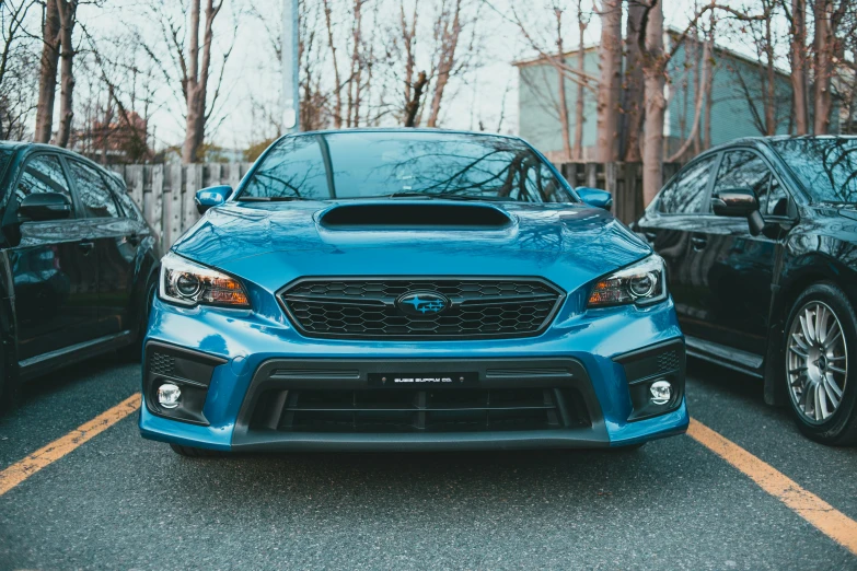 two subarunts parked in a row, one blue and one black