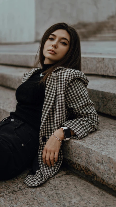 a woman is sitting on the stairs in front of some steps