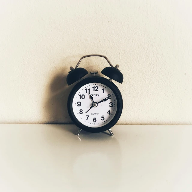 a small alarm clock on a counter next to a wall