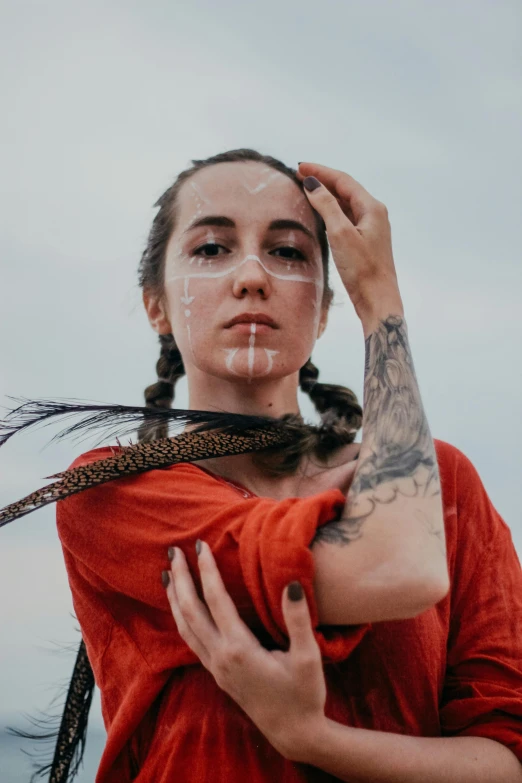 woman with tattoo holding on to her neck