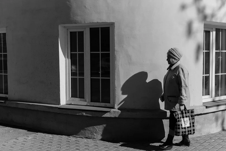 a person holding a bag is standing by the window