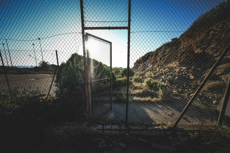 a gate with a sun shining through it