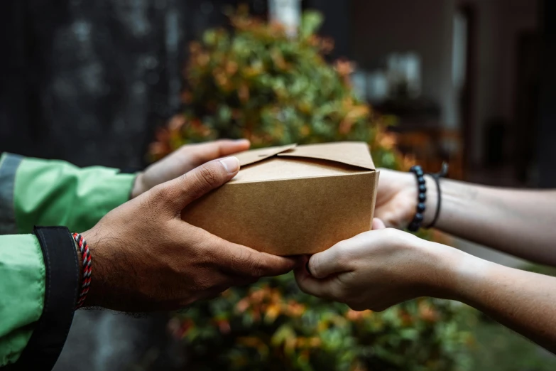 two people are holding a brown box in their hands