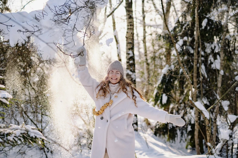 a girl is throwing snow in the air