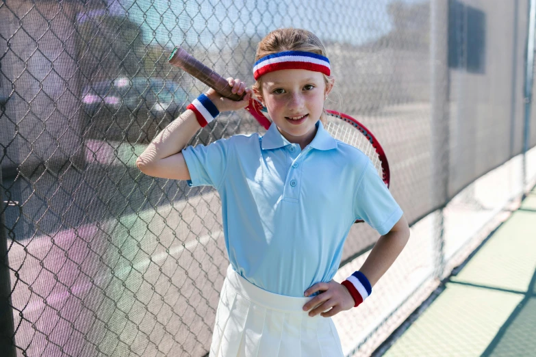 a  poses for a pograph while holding a tennis racket