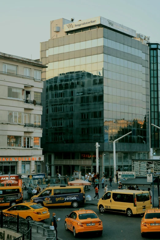 a bunch of taxi cabs are in front of a tall building