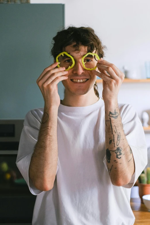 a man holding yellow glasses up over his eye