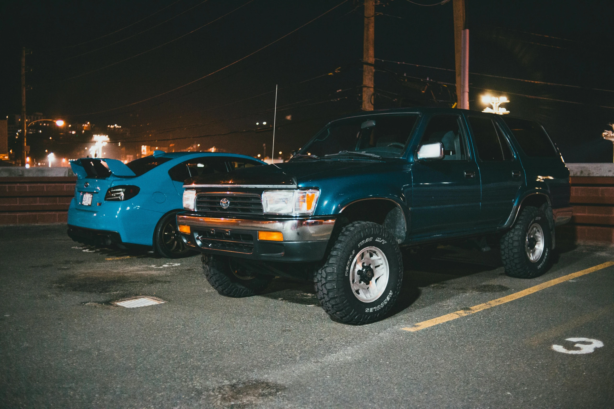 this is two cars parked in a parking lot