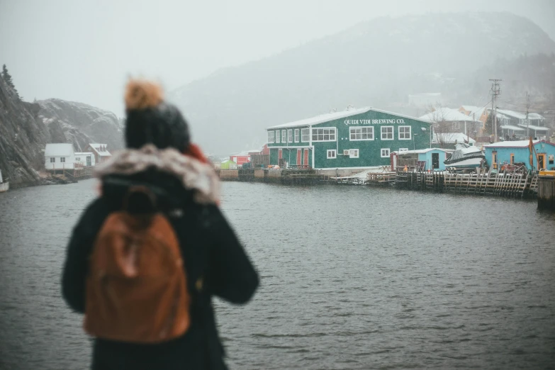 a woman standing next to a body of water