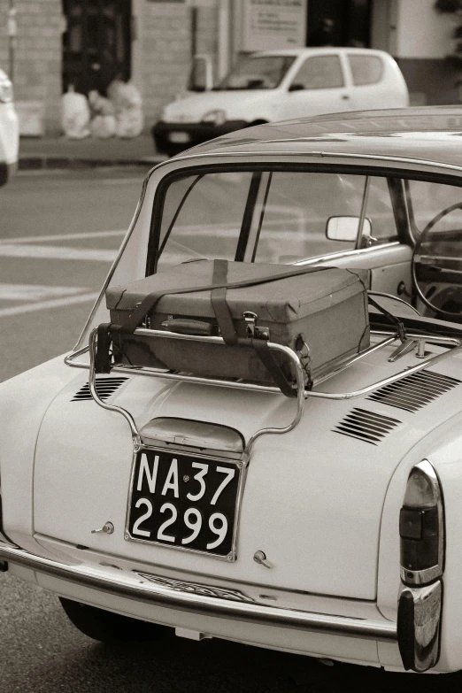 an old car with the hood up parked on the street