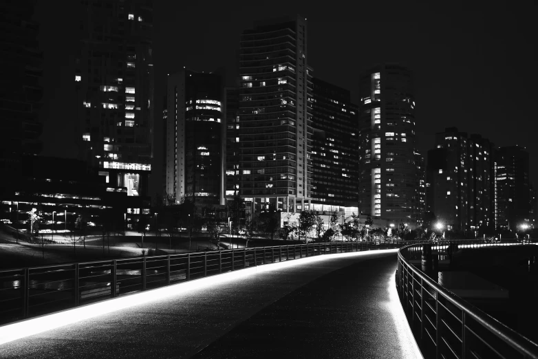 the night lights illuminate the silhouette of large buildings on the horizon