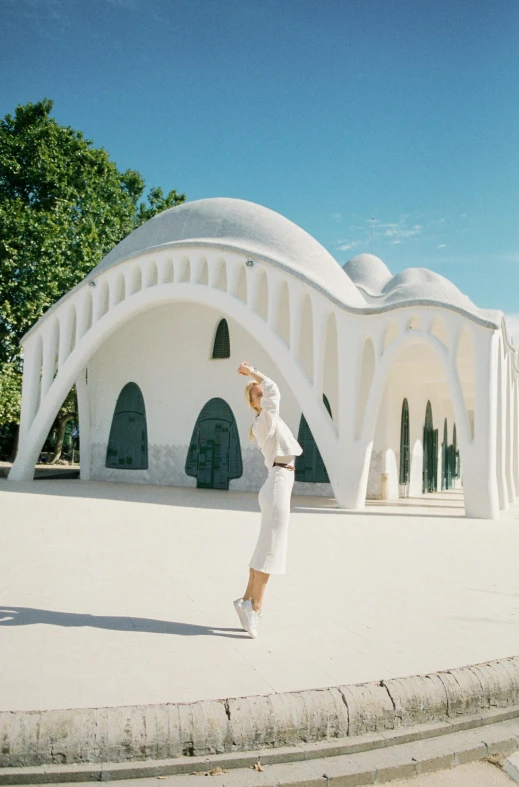 there is a woman standing outside of a white building