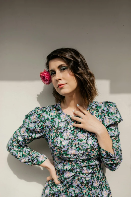 a woman with a flower in her hand poses for a po