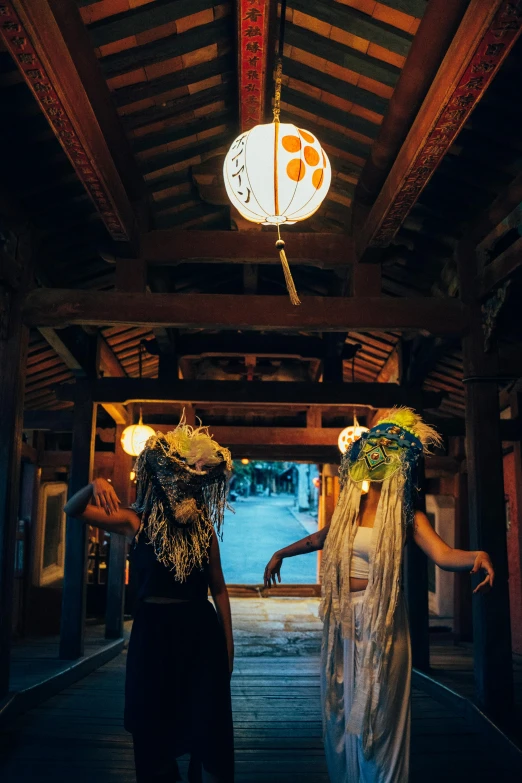 two women wearing hawaiian themed costumes in a wooden walkway