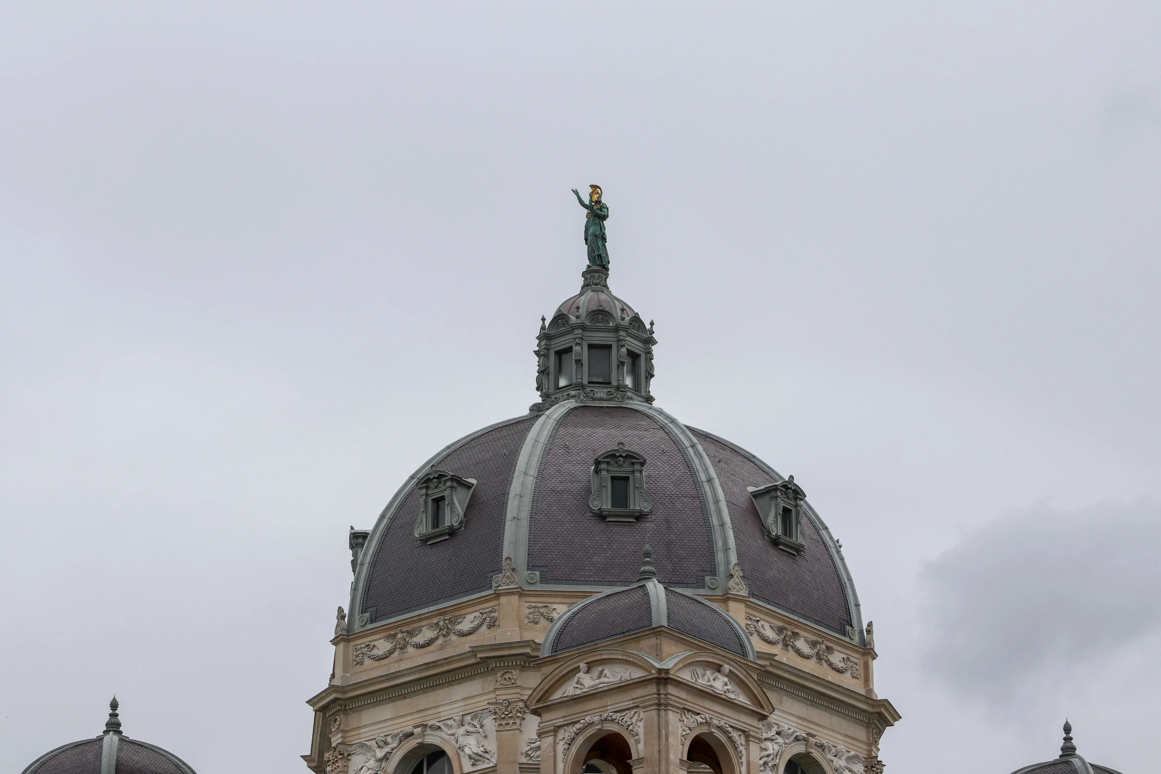 an ornate building with two statues on top