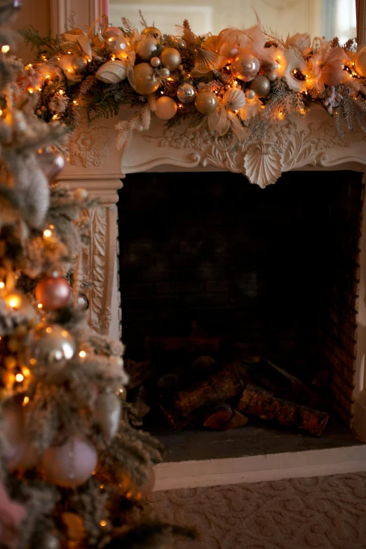 decorated christmas tree next to fireplace with burning logs