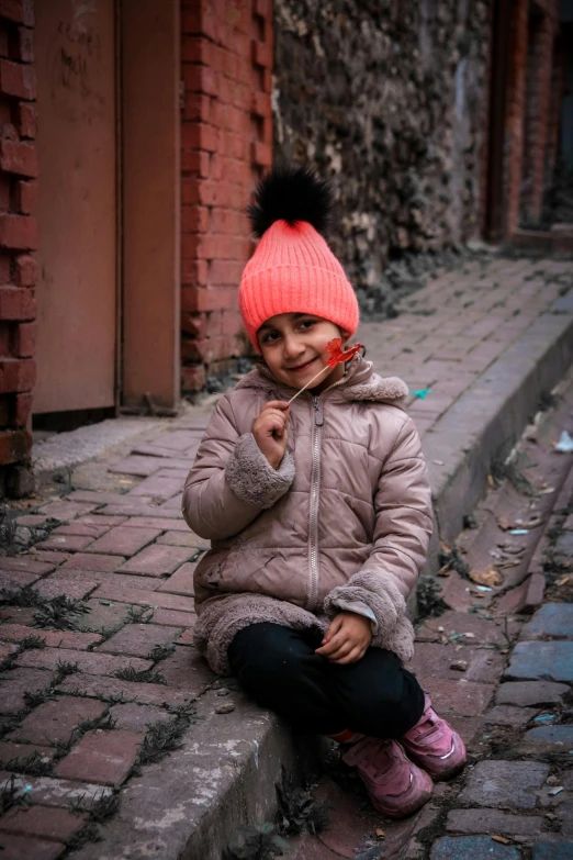 a young child sits on a brick road