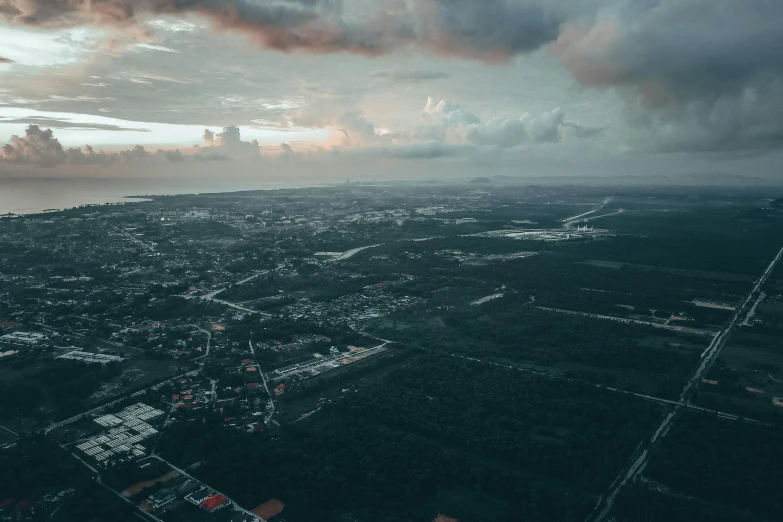 an aerial view of a city in the distance and cloudy skies