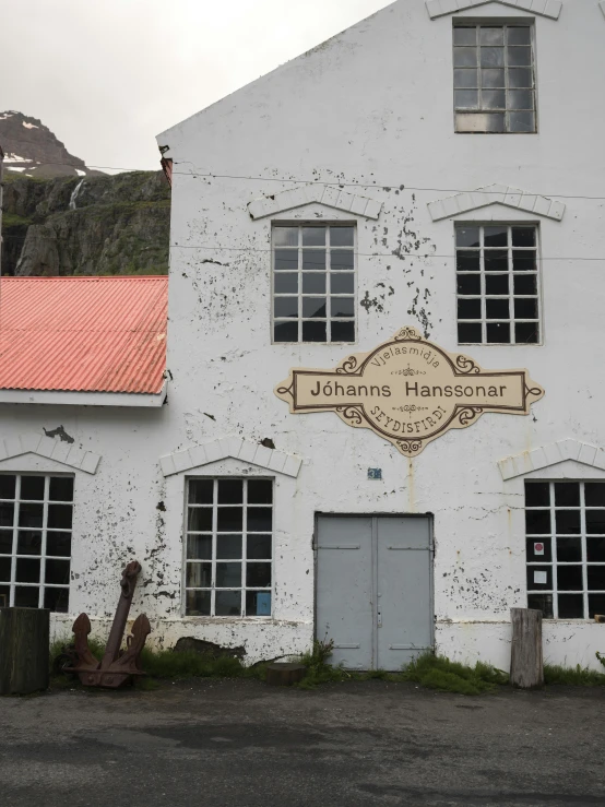 an old white building with two doors that say, johnny hancock