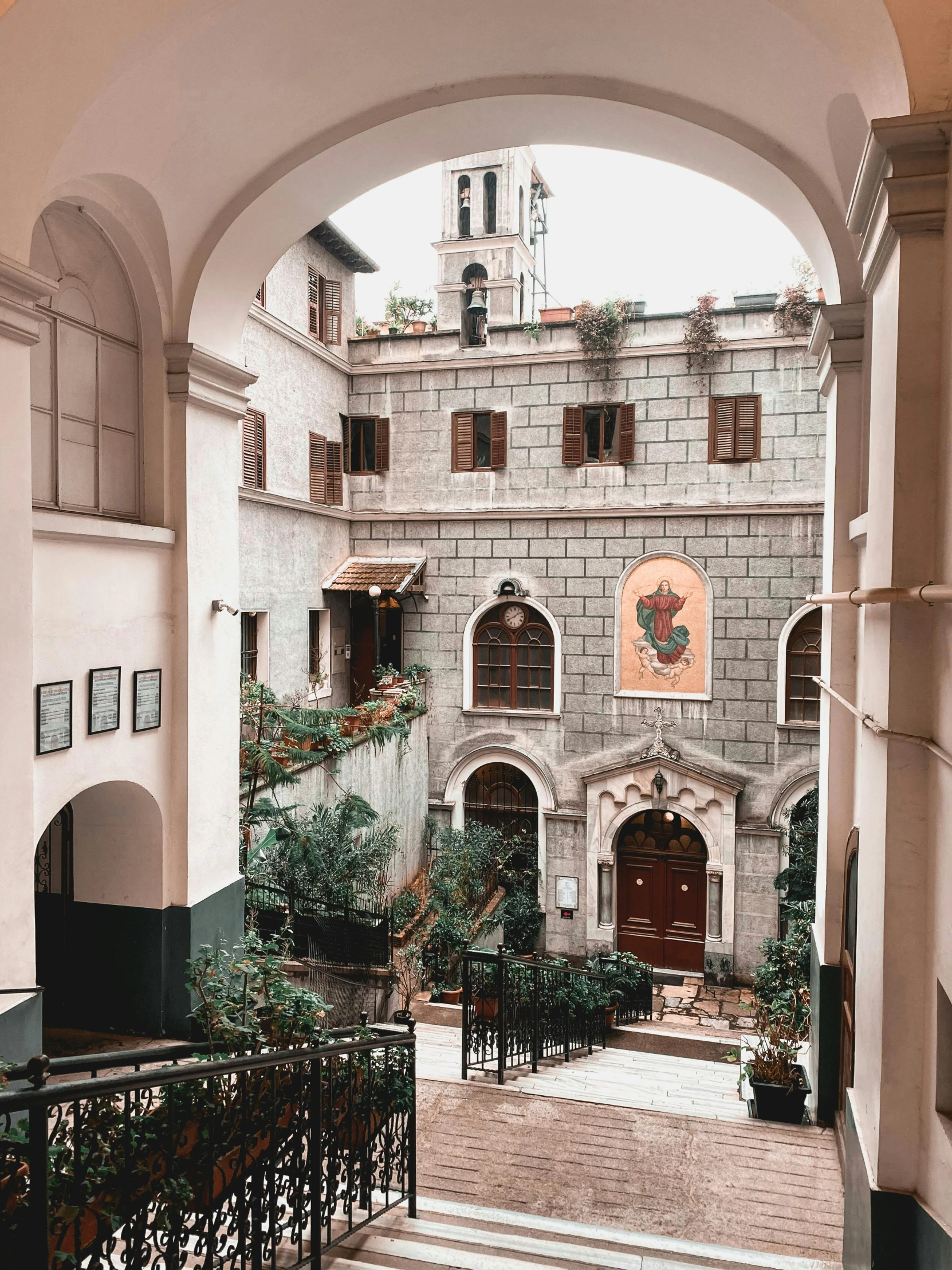 an arched entrance way to a house with several plants