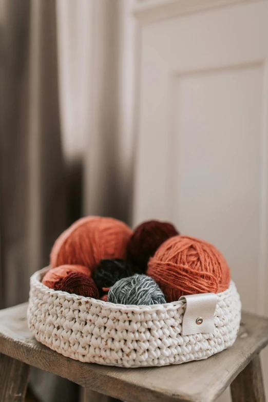 balls of yarn are sitting in a crocheted basket