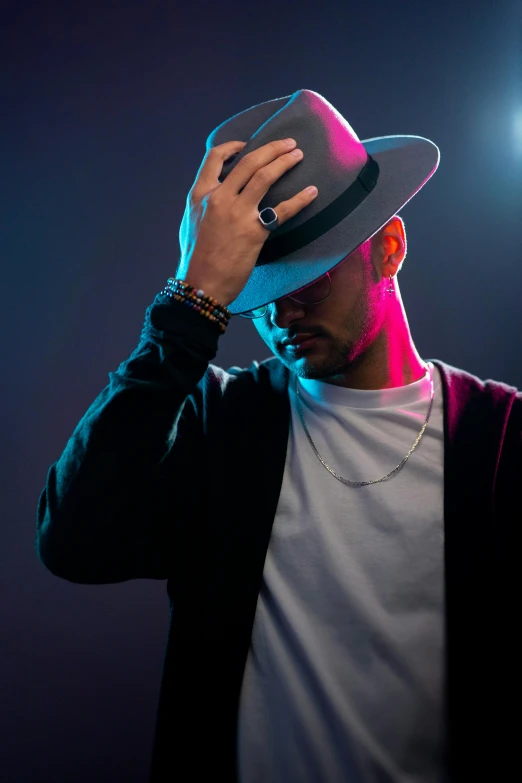 man in a hat standing up with his head resting on his hat