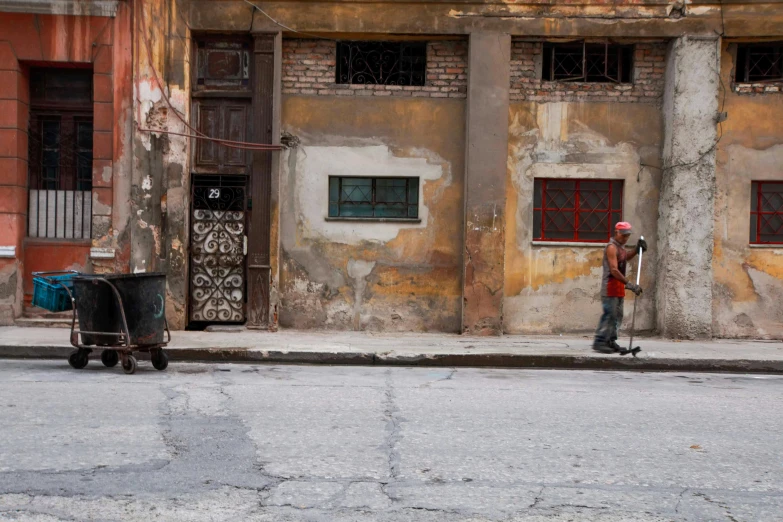 a man on a skateboard by a dirty building