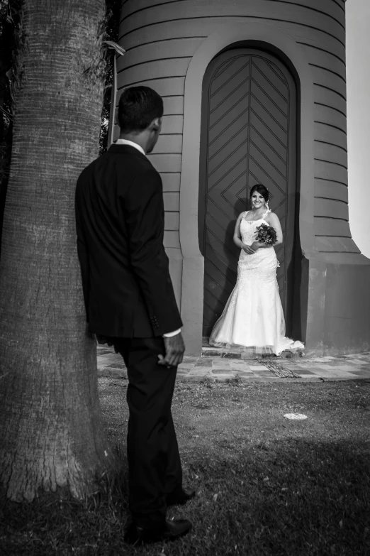 the couple pose by the entrance of their home