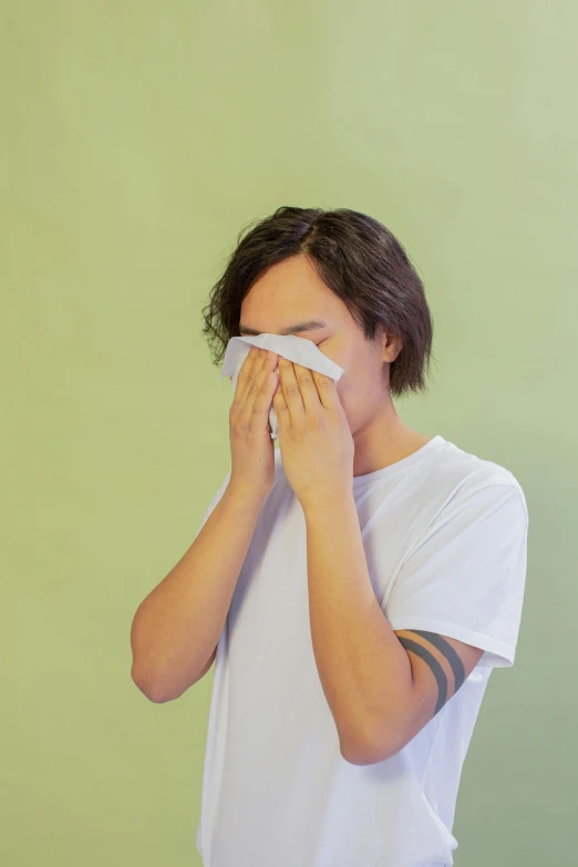 a man covers his face with an handkerchief