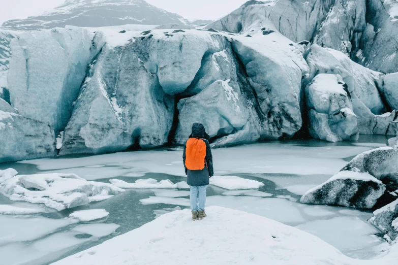 a man standing on ice with mountains in the background