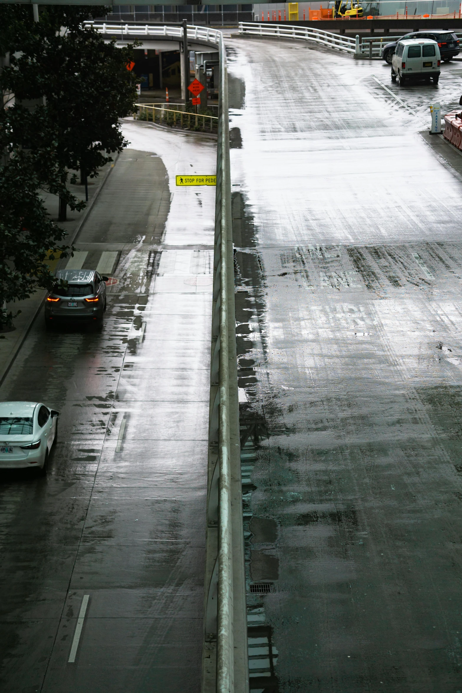 cars travel down a wet road during a rain storm