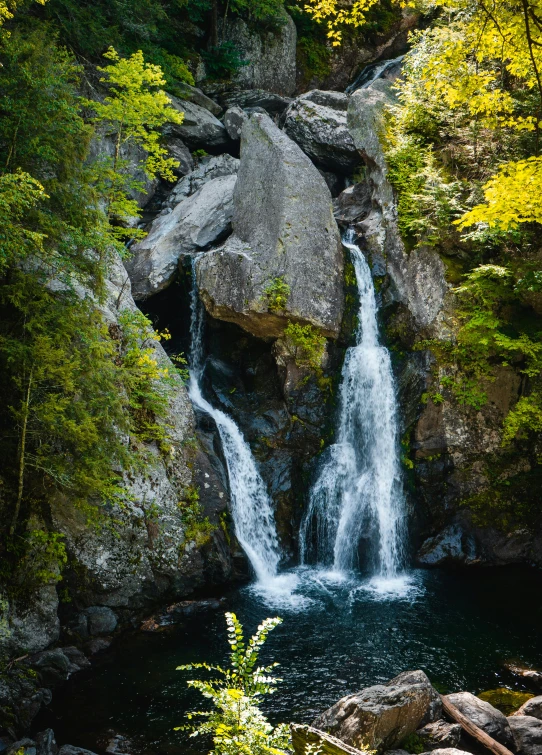 a large rock sitting in the middle of a water fall