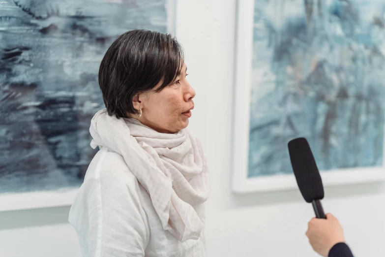 woman with microphone talking to another person