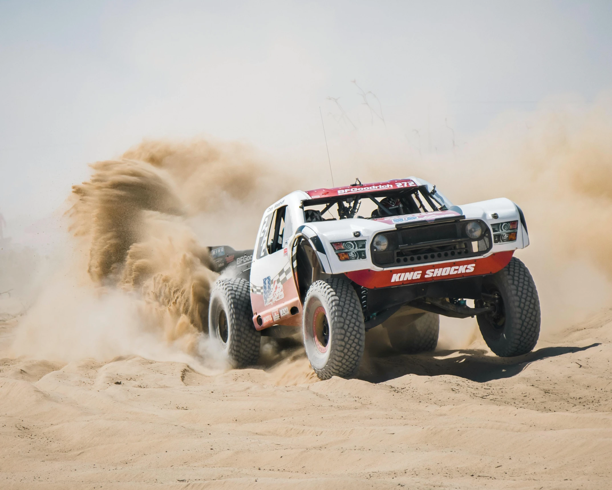 a truck driving through some sand in the desert