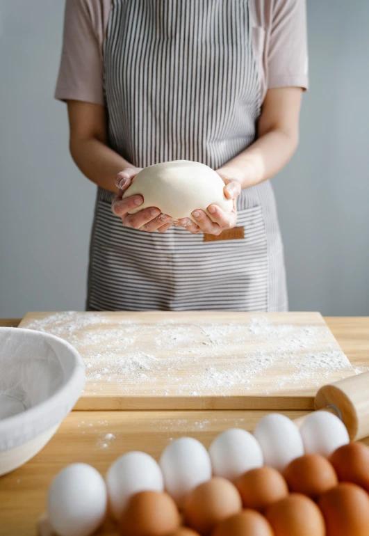 a woman holding a ball in one hand and eggs in the other