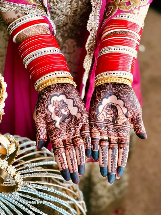 a person holding onto a henna while standing in front of a golden vase