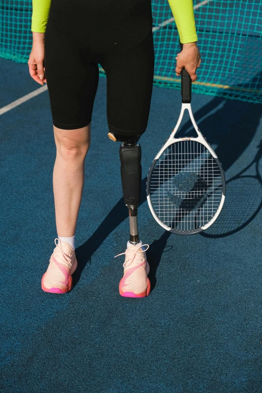 a person with an inflatable leg holding a tennis racket