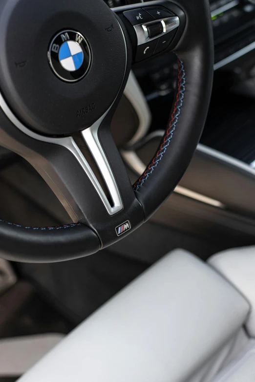 a steering wheel, dash light and leather panel in a bmw