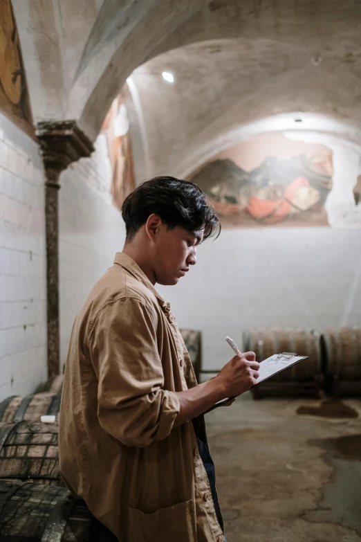 a person writing in a paper next to a wine cellar