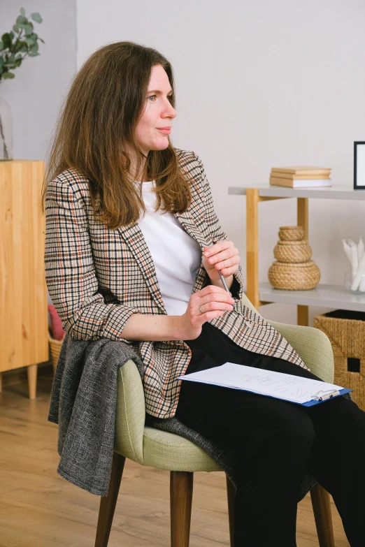 a woman in white shirt sitting on a green chair